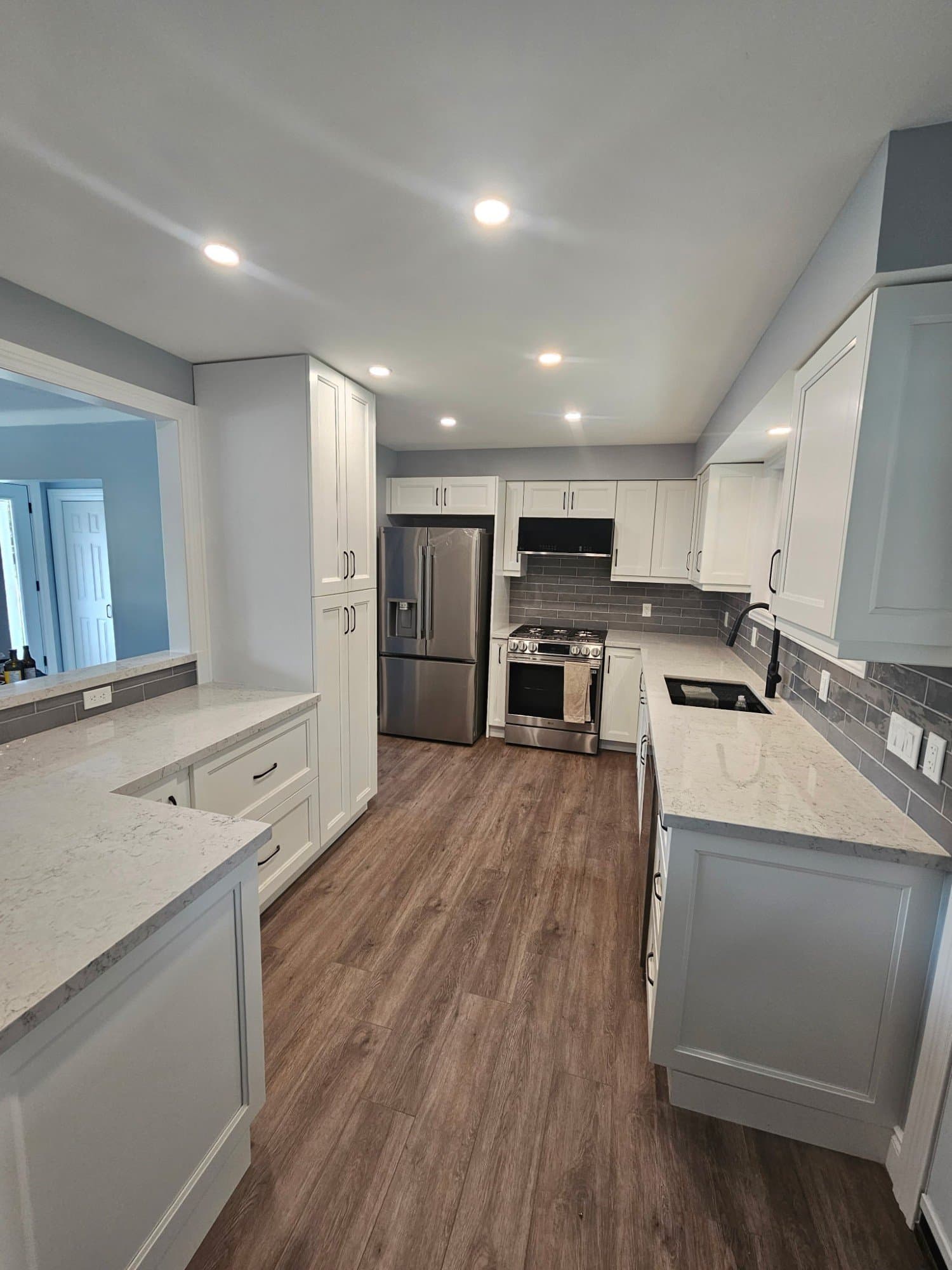 Newly renovated kitchen with quartz countertops and custom white cabinetry
